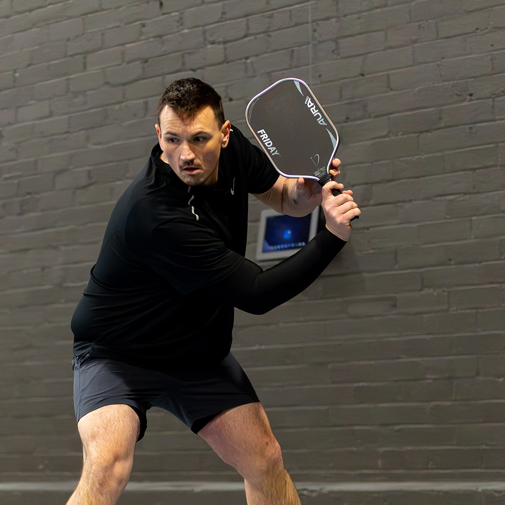 Player holding the Friday Aura Pro Metallic pickleball paddle